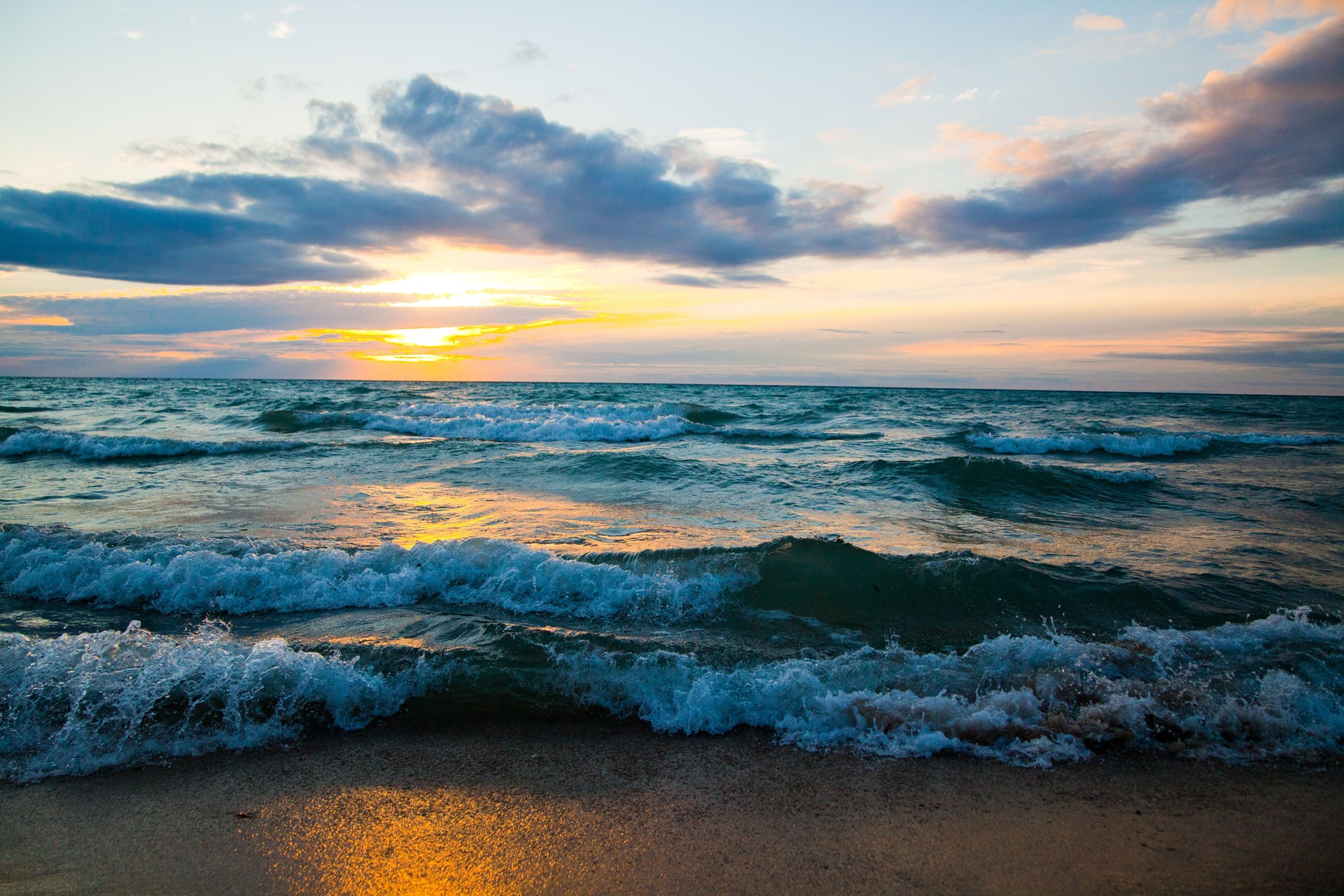 Tranquil Sunset Over Lake Michigan with Rolling Waves and Golden Glow
